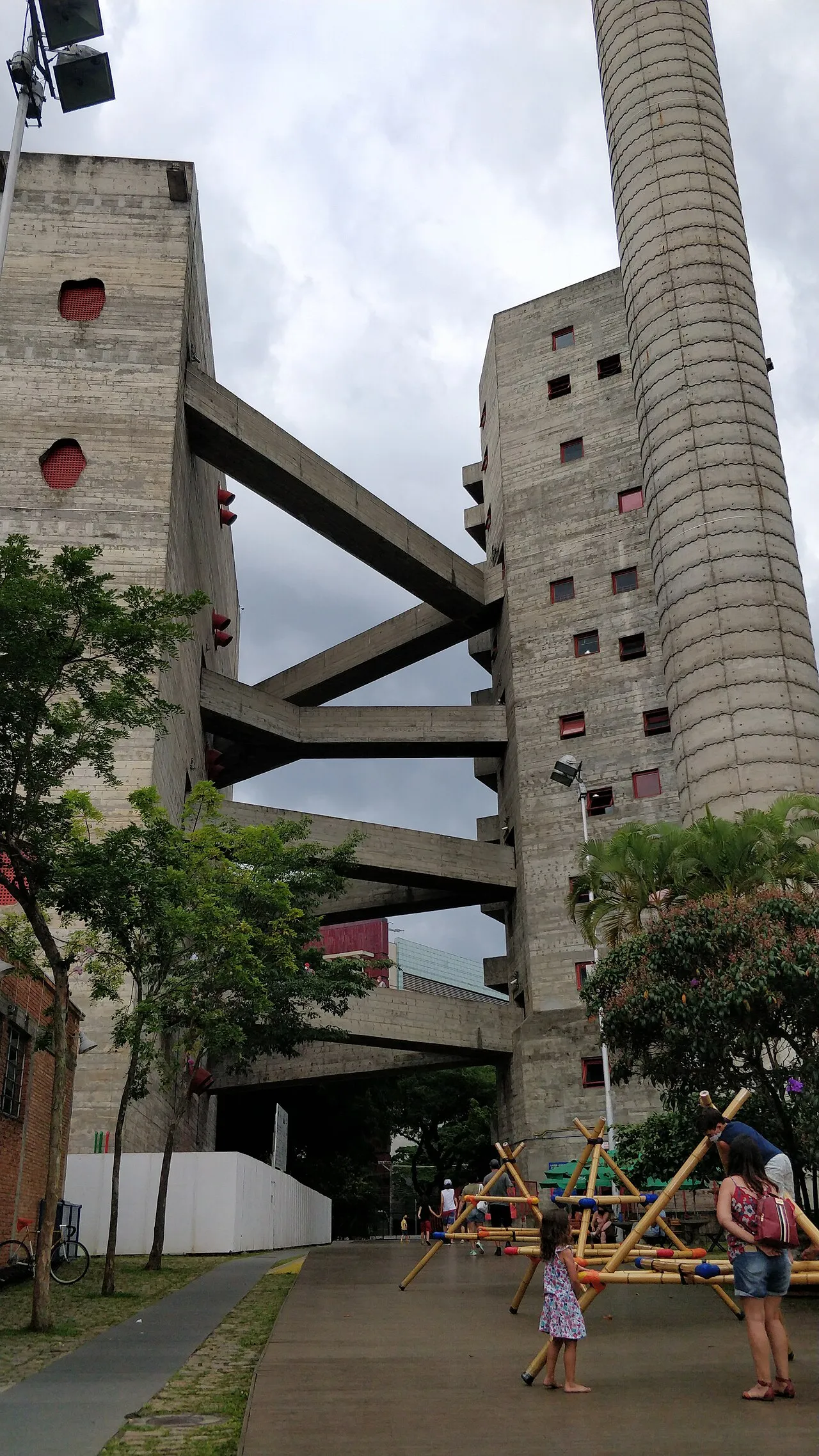Children play in front of a warm concrete building,.