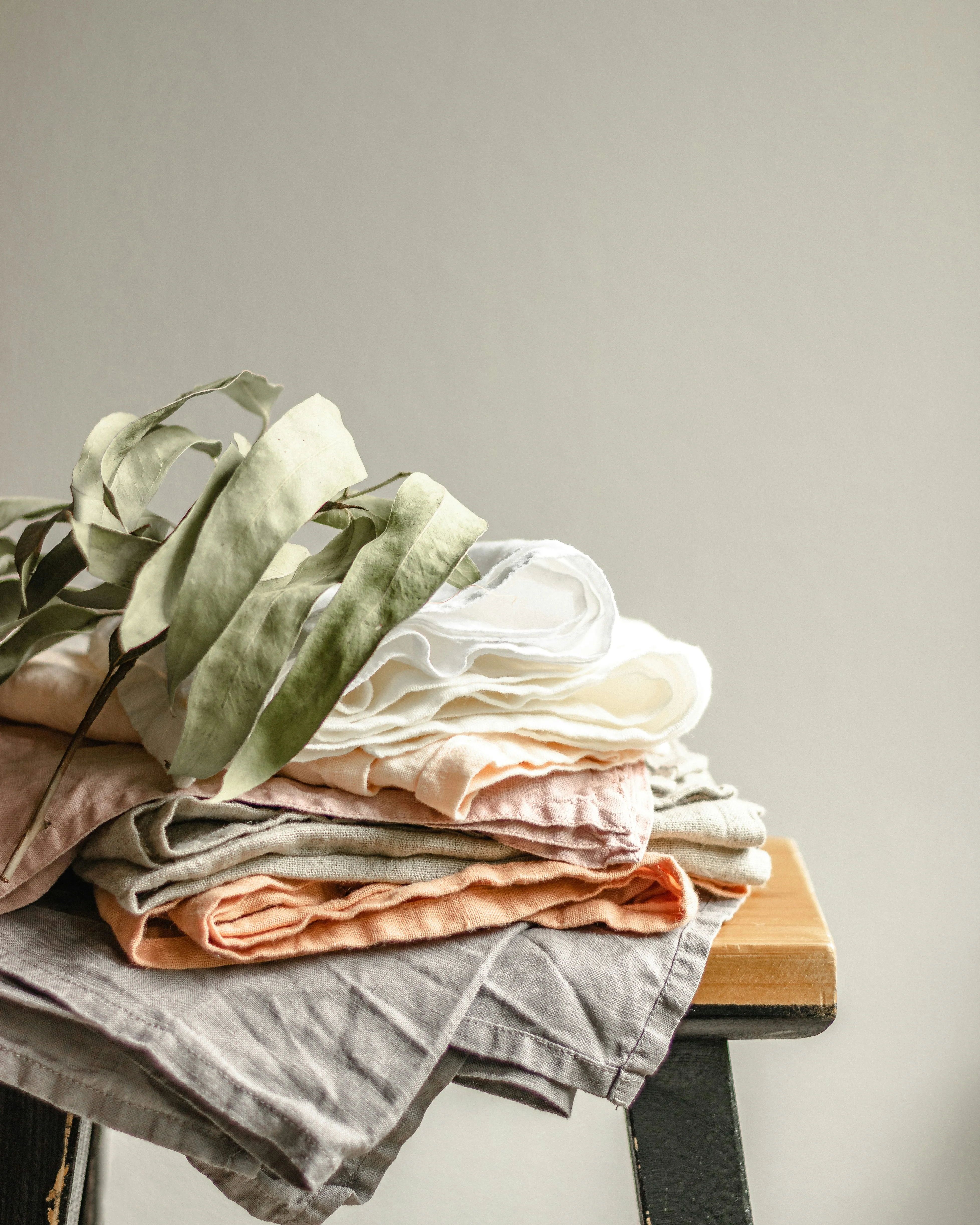 A untidy pile of natural toned linen sheets