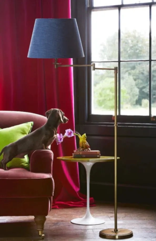 The Swing articulated standing lamp — brass arm, adjustable, with a straight stem