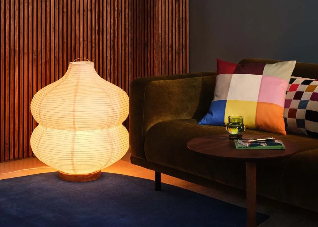 A selection of considered floor lamps photographed against a warm dark interior.